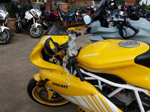 Yellow Ducati motorcycle parked among various other bikes.