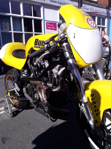 Yellow motorcycle with a distinctive design, parked on a street.